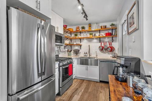 una cucina con elettrodomestici in acciaio inossidabile e un tavolo in legno di Ranch Style, King Bed, Guitar, BBQ- 1 Dollar rides to Beach & Downtown a Lake Worth