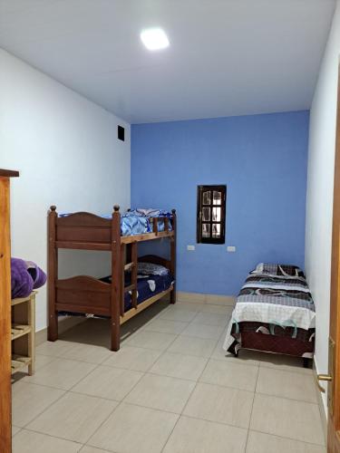 a room with two bunk beds and a blue wall at Finca La Fortaleza zanjon in Santiago del Estero