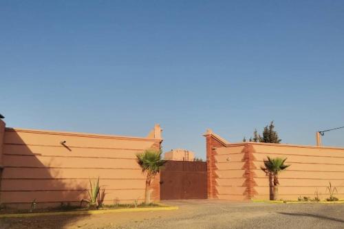 two fences with palm trees in front of them at Marrakech Luxury Villa Farm in Marrakech