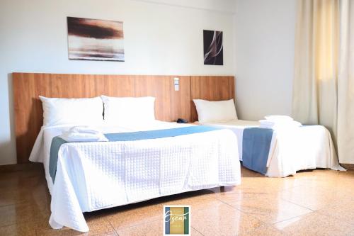 a bedroom with two beds with white sheets at Hotel Oscar Blue Montes Claros in Montes Claros