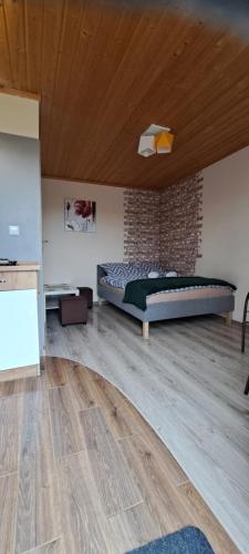 sypialnia z łóżkiem i ceglaną ścianą w obiekcie Chrząszczewo Widokowe Wzgórze w mieście Uherce Mineralne (7)
