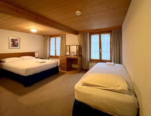 una habitación de hotel con 2 camas en una habitación en Chalet Rosa B&B, en Lauterbrunnen