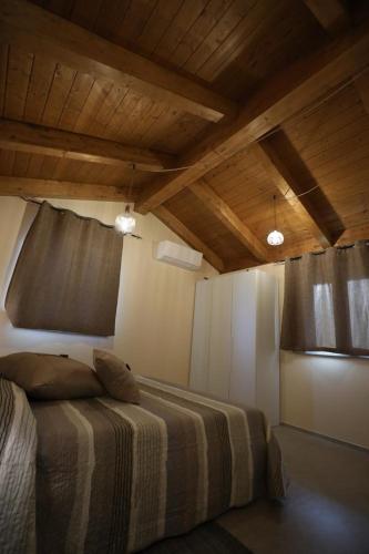 a bedroom with a bed in a room with wooden ceilings at Il Fienile in Magliano Alpi