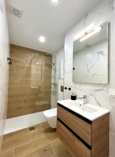 a bathroom with a sink and a toilet and a mirror at Perseo by Albir Proper Properties in Albir