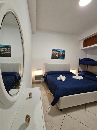 a bedroom with two beds and a mirror at Clary Home Cefalu' in Cefalù