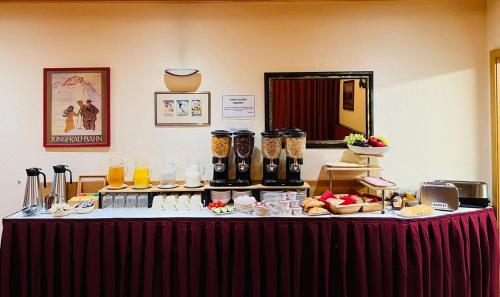 a table with food and drinks on top of it at Chalet Rosa B&B in Lauterbrunnen