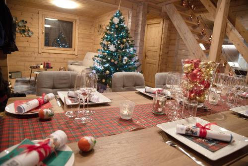 Gîte La Perhotte في Solgne: طاولة عيد الميلاد مع شجرة عيد الميلاد في الغرفة