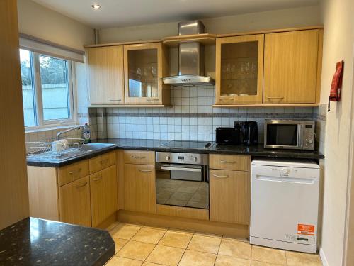 a kitchen with wooden cabinets and a stove top oven at Home in Oxford in Oxford
