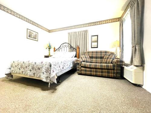 a bedroom with a bed and a couch and a chair at Bittersweet Inn in Paulding