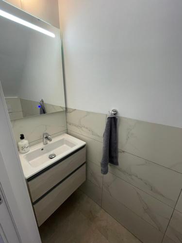 a white bathroom with a sink and a mirror at Las Americas Bungamar apartment in Playa de las Americas