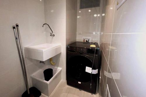 a bathroom with a sink and a washing machine at Rodadero- Ámbar Deluxe in Santa Marta
