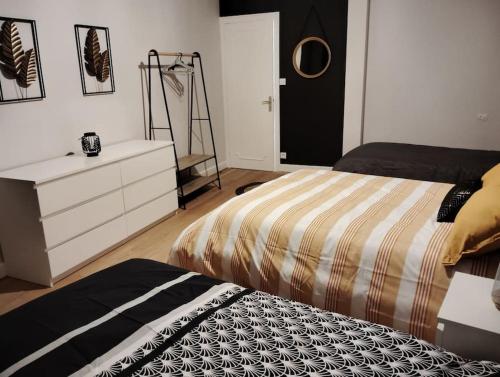 a bedroom with a bed and a dresser and a dresser at Issoudun appart élégant 150m² in Issoudun