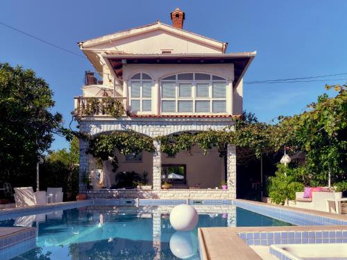 una casa con piscina frente a una casa en Art Villa Ines en Zadar