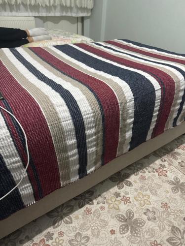 a bed with a striped blanket on top of it at Hometex in Istanbul