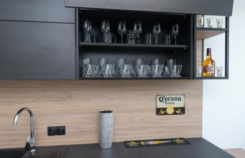 a kitchen counter with wine glasses on a shelf at Солнечные просторные апартаменты Метро Минская in Kyiv