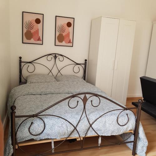 - une chambre avec un lit en métal et deux photos sur le mur dans l'établissement Studio hôtel-Dieu, à Nantes