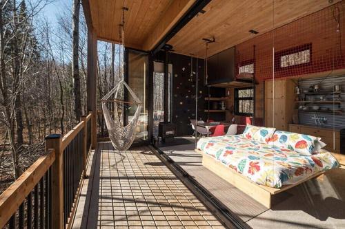 porche con cama y hamaca en la terraza en Cabin Zoobox 56, en Eastman