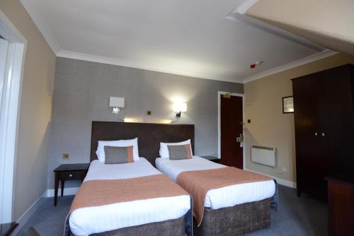 a hotel room with two beds in a room at Columba Hotel in Oban