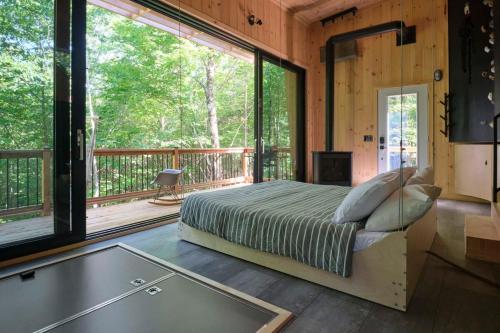 1 dormitorio con cama y ventana grande en Cabin Zoobox 57, en Eastman