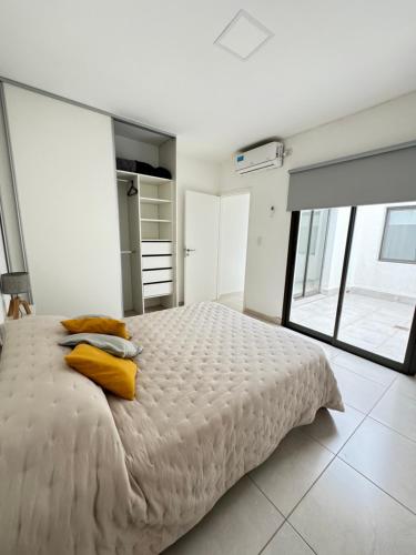 1 dormitorio con 1 cama blanca grande con almohadas amarillas en Complejo Carrodilla - Lujan de Cuyo en Luján de Cuyo