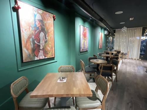 a restaurant with tables and chairs and a painting on the wall at 38 Apartment 2 in Pristina