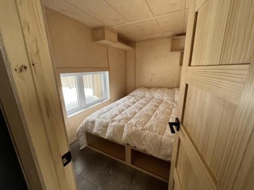 a small bedroom with a bed and a window at Cabin Zoobox 63 in Eastman