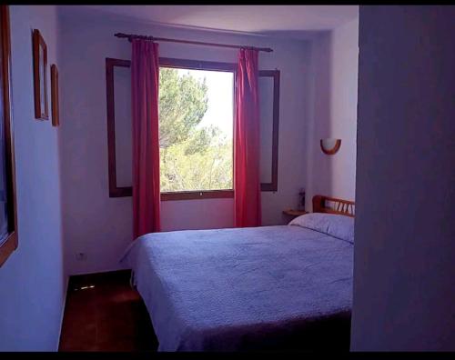 Sol Isla في أرينال دو ان كاسيل: غرفة نوم بسريرين ونافذة ذات ستائر حمراء
