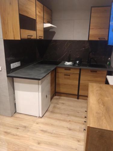 a kitchen with wooden cabinets and a counter top at Bydgoszcz Kawalerka 2 in Bydgoszcz