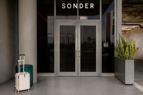 una valigia è seduta fuori da una porta di vetro di Sonder by Marriott Bonvoy 17WEST Apartments a Miami Beach