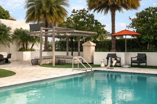 a swimming pool with a pavilion and palm trees at Sonder 17WEST in Miami Beach