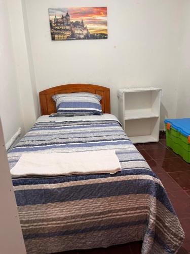 卡拉馬的住宿－Residencial Amanda Josefa，一间卧室配有带条纹毯子的床
