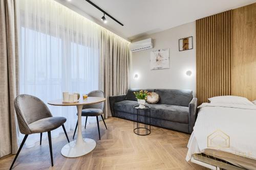 Un dormitorio con una cama, un sofá y una mesa. en Kilińskiego Residence, en Łódź