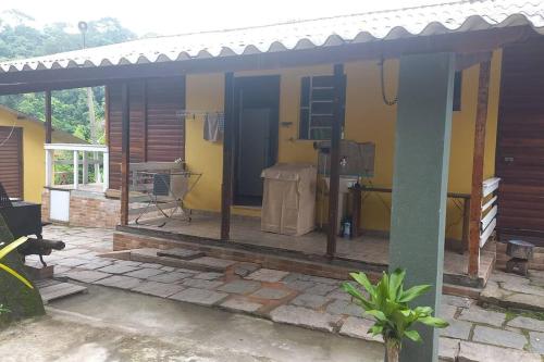a house with a porch with a patio at Chalé urbano in Miguel Pereira