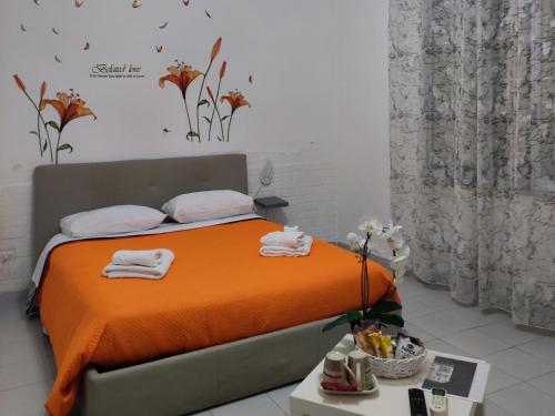 Un dormitorio con una cama naranja con toallas. en Le tre orchidee, en Salerno