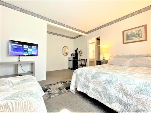 a room with two beds and a tv on the wall at Bittersweet Inn in Paulding