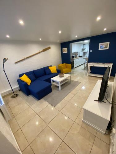 - un salon avec un canapé bleu et des oreillers jaunes dans l'établissement Maison de pêcheur typique, à Étaples