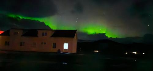aurore au-dessus d'une maison et d'un bâtiment la nuit dans l'établissement Kviholmi Premium Apartments, à Hvolsvöllur