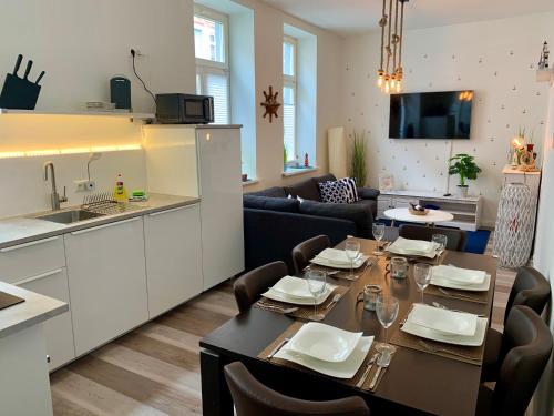 a kitchen and a dining room with a table and chairs at N A U T I C A - ruhige maritime Ferienwohnung mit Balkon familienfreundlich in Rostock