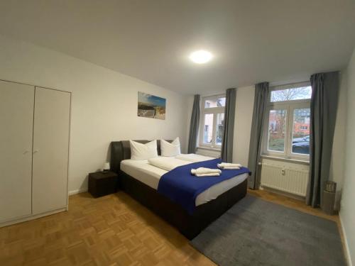 a bedroom with a bed with a blue blanket at Apartment BERNSTEIN ruhig, familienfreundlich mit Garten in Rostock