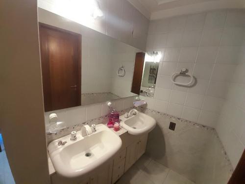 W białej łazience znajduje się umywalka i lustro. w obiekcie Elegante piso en barrio privado w mieście Godoy Cruz
