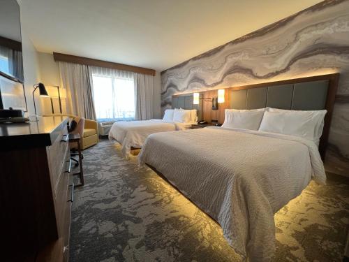 沃思堡的住宿－沃斯堡北- 化石溪假日酒店，酒店客房设有两张床和大窗户。