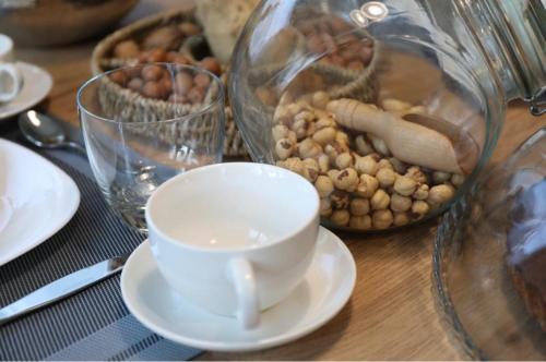 a table with a coffee cup and a jar of food at Il Fienile in Magliano Alpi
