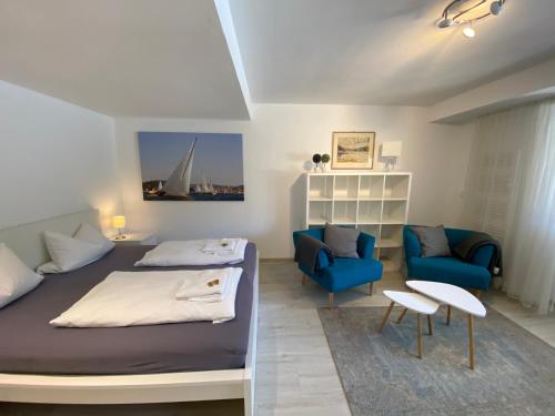 1 dormitorio con cama, sofá y sillas en Comfort-Appartment, en Überlingen