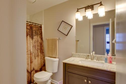 a bathroom with a toilet and a sink and a mirror at Greensboro Vacation Rental Condo Near Downtown in Greensboro