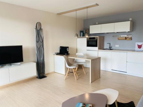 a living room with a kitchen and a table with chairs at Apartment EigenArt in Owingen