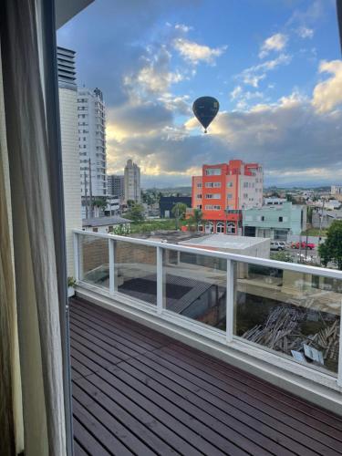 einem Heißluftballon, der von einem Balkon über eine Stadt fliegt in der Unterkunft Apto duplex Lagoa do Violão in Torres