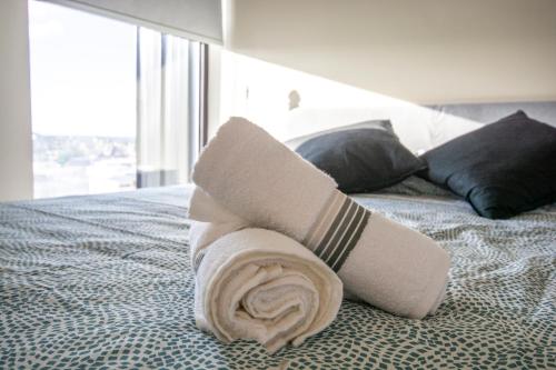 Una toalla enrollada encima de una cama en Luxury Revolución Ave/Pool/PKG, en Tijuana