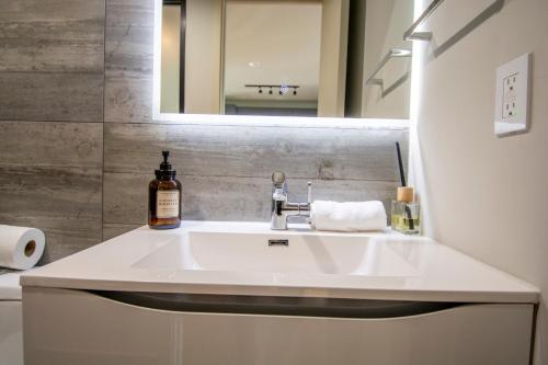 y baño con lavabo blanco y espejo. en Luxury Revolución Ave/Pool/PKG, en Tijuana