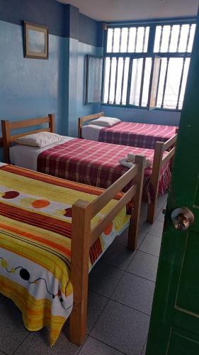 um quarto com três camas num quarto em JULIA'S HOUSE em Huanchaco