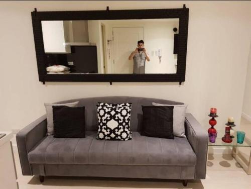a man taking a picture of a couch in front of a mirror at Penthouse Apartment in Paranaque in Manila